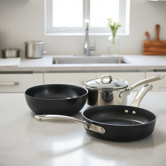 Neatly arranged nonstick skillet and saucepan on a kitchen countertop in soft natural light